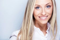 Woman in her thirties smiling, her face rejuvenated after plastic surgery