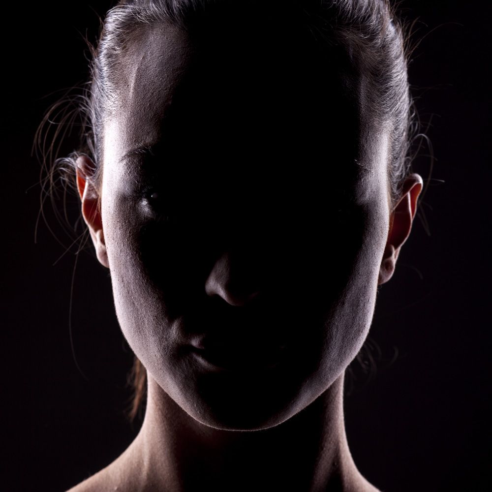 A woman's face covered in shadow