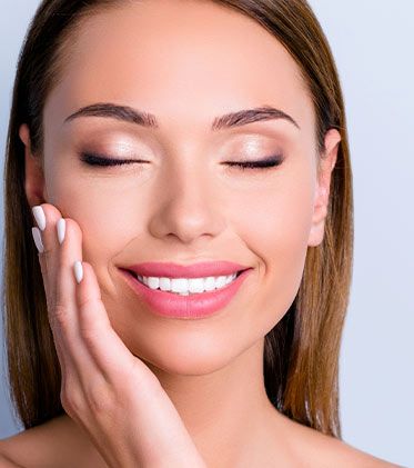 Smiling woman touching face