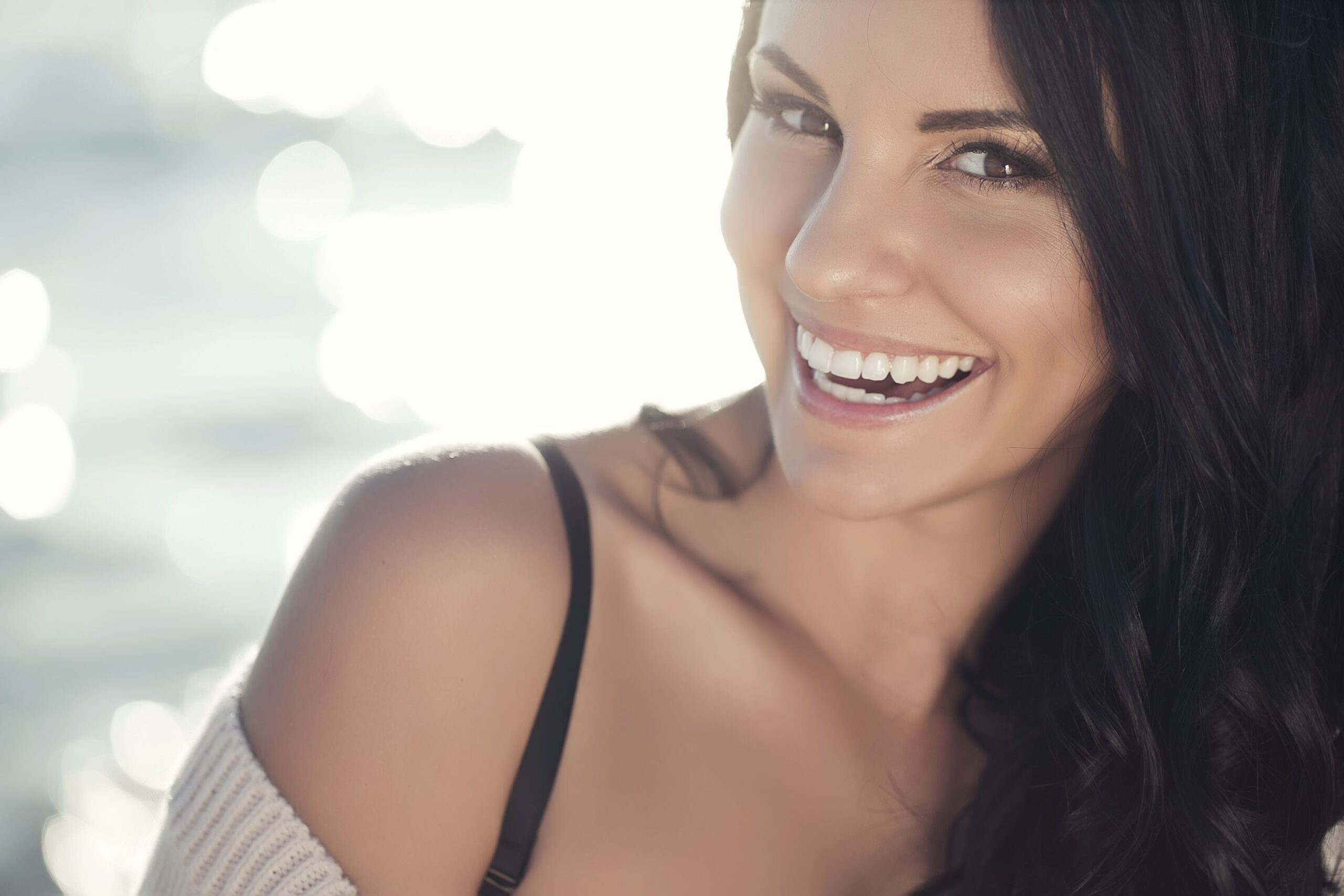 A woman smiling broadly because she has taken years off her appearance through facial plastic surgery